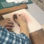 竹組に貼った和紙をタワシを使ってしっかり押さえている写真